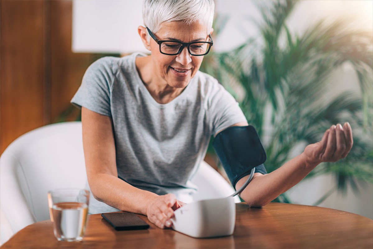 Woman taking her blood pressure at home